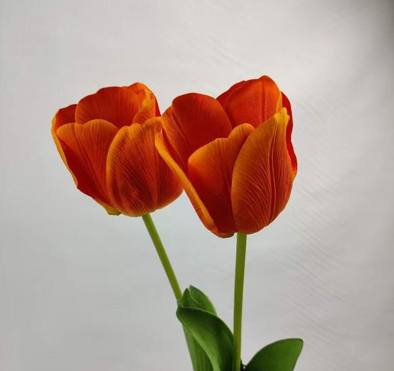 two artificial real touch orange tulips